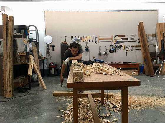 2017-2018年冯晓峰在制作《回溯NO.6》，冯晓峰有不少作品都是用木头制作，多年处理木料的娴熟技艺，背后整整齐齐的工具，让他看起来更像一名老练的木工。.jpg