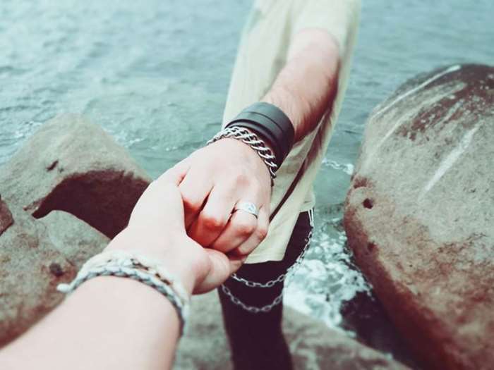 couple-holding-hands-near-rocks-by-sea.jpg
